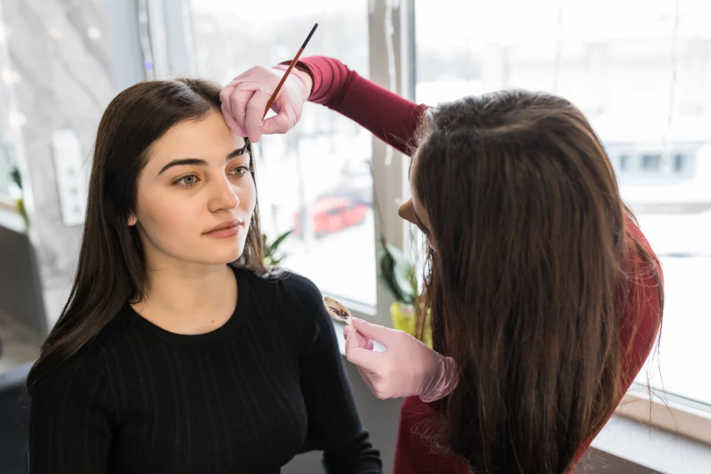 female master put eyebrow paint with brush make up procedure