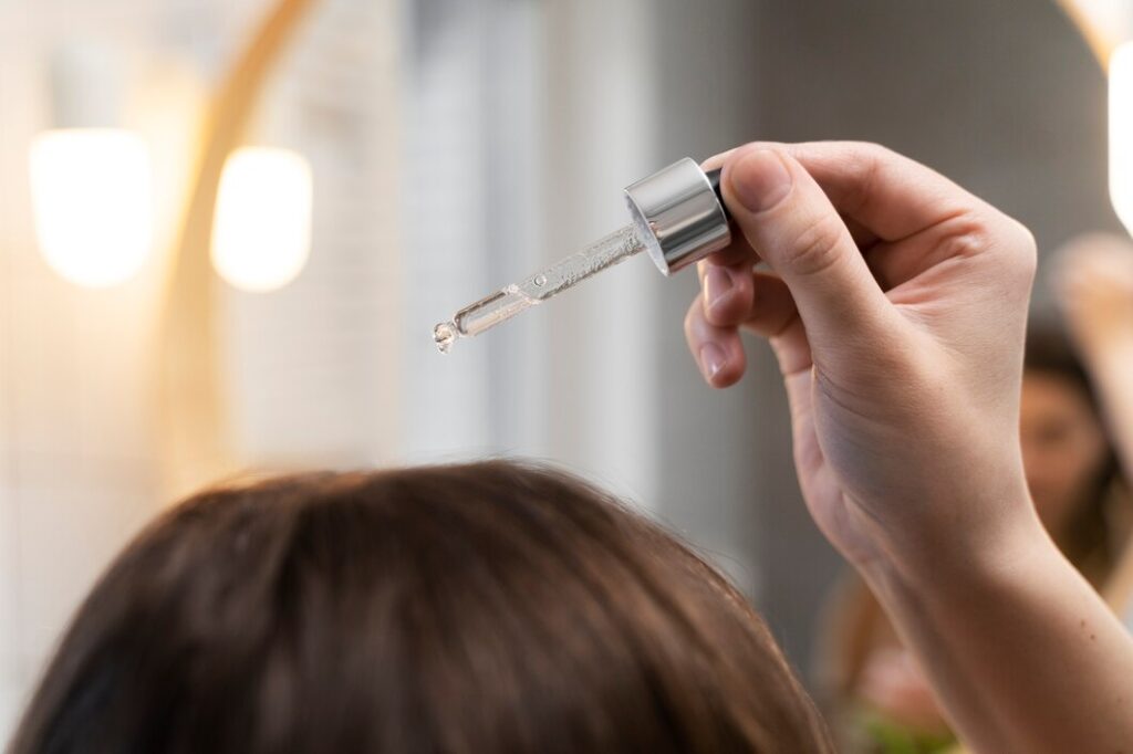 Young woman applying anti dandruff product